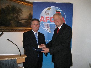 Lentz (l) receives a token of appreciation from Brig. Gen. Scherz after Lentz's speech at the June event.